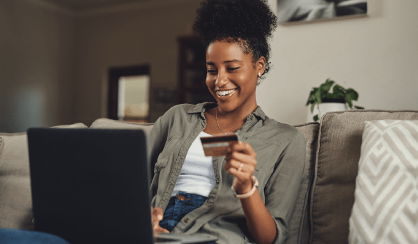 Woman typing in a credit card number on her computer